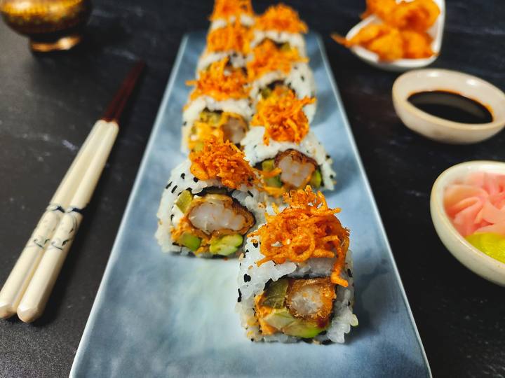 Prawn tempura uramaki rolls with crispy orange topping on a pale blue plate